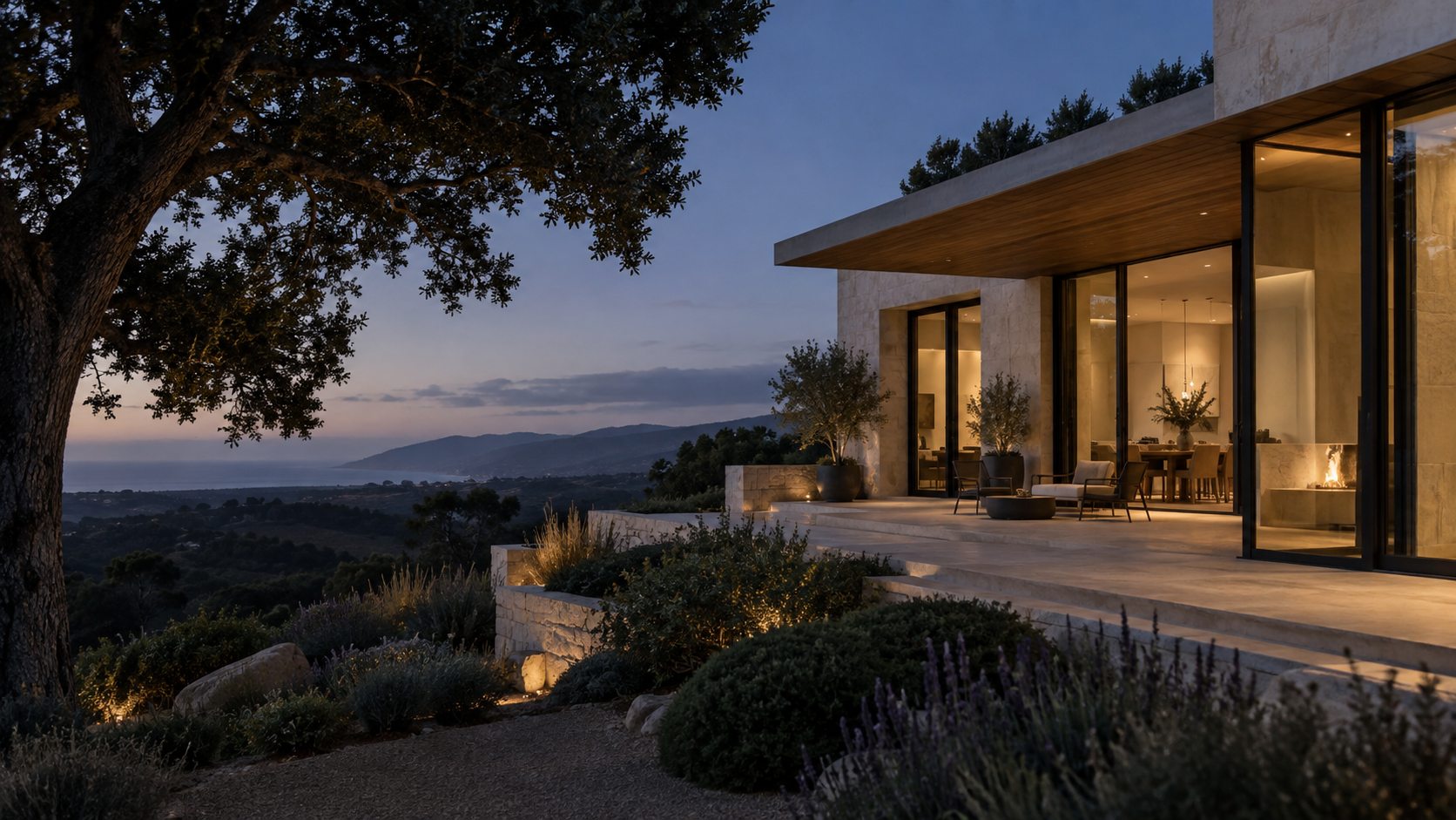 Contemporary California home with warm interior lighting and coastal hills at dusk